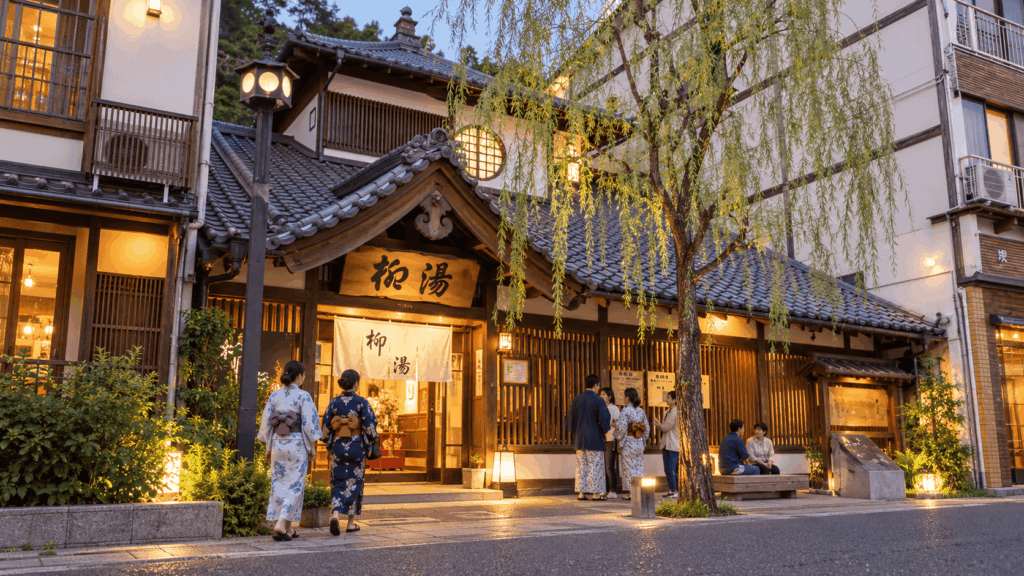 Yanagi-yu public bath entrance with yukata-clad visitors in Kinosaki Onsen