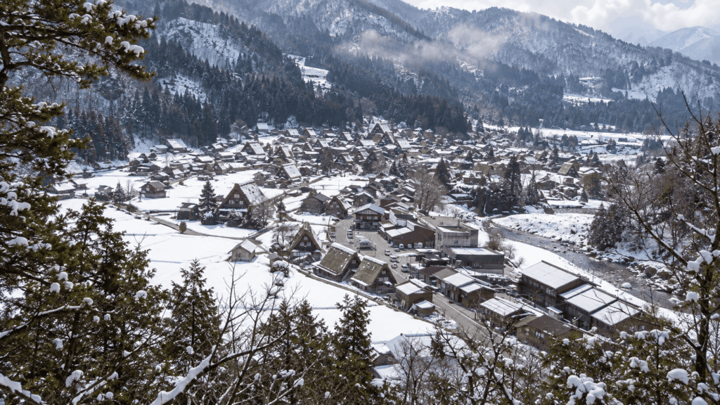 Panoramic view of snow-covered Shirakawa-go village and traditional thatched-roof houses from the Ogimachi Castle Observation Deck