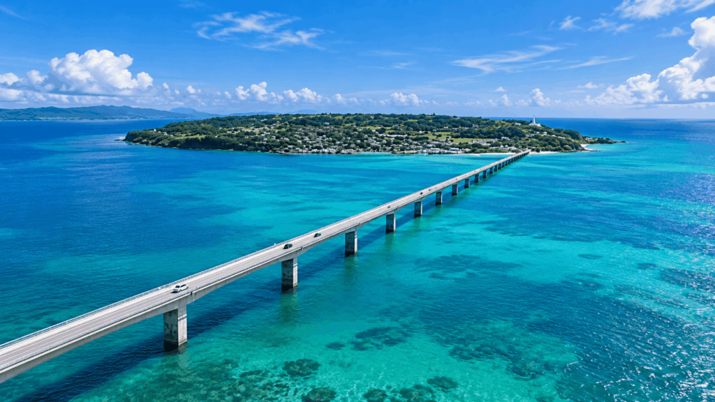 Aerial view of Kouri Bridge stretching across crystal-clear turquoise waters toward Kouri Island in Okinawa