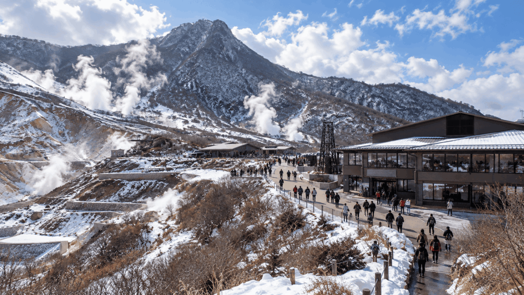 Steam rising from the snowy volcanic landscape of Owakudani in Hakone as visitors explore the geothermal valley