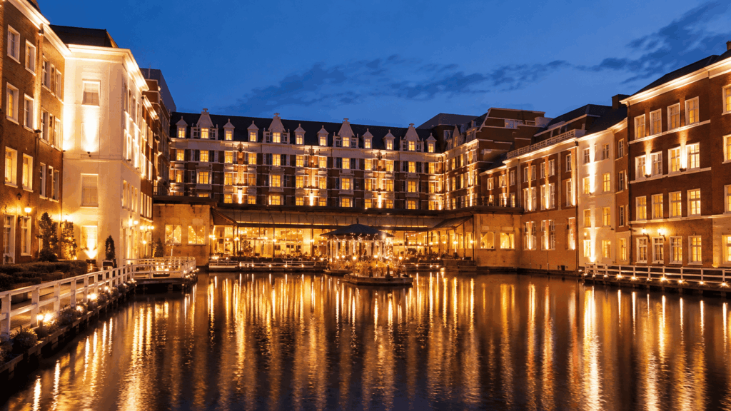 Illuminated European-style hotel buildings reflected in a waterfront canal at Huis Ten Bosch in Nagasaki at dusk