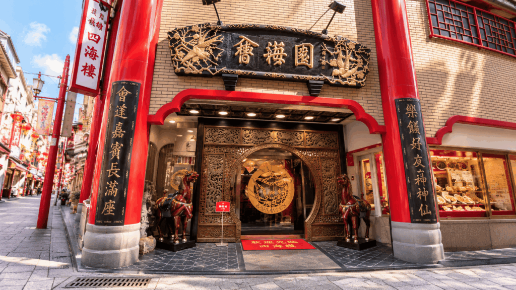 Entrance of Kairakuen Chinese restaurant in Nagasaki Chinatown, decorated with red pillars, ornate carvings, and traditional Chinese designs
