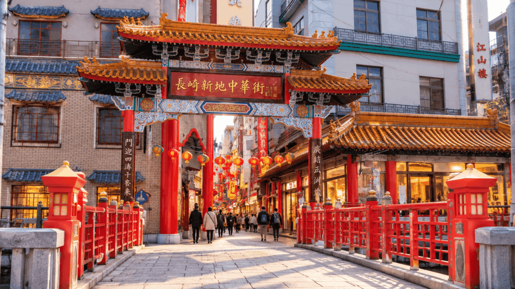 Traditional Chinese entrance gate at Nagasaki Shinchi Chinatown, decorated with red pillars, golden roofs, and hanging lanterns