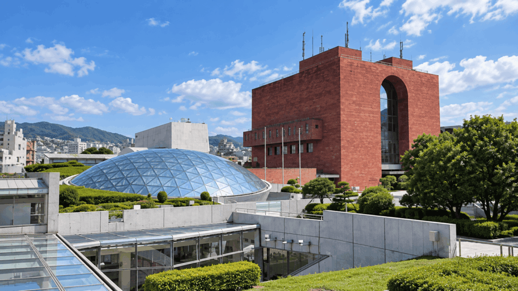 Exterior of the Nagasaki Atomic Bomb Museum, featuring a modern brick building, glass dome, and landscaped gardens