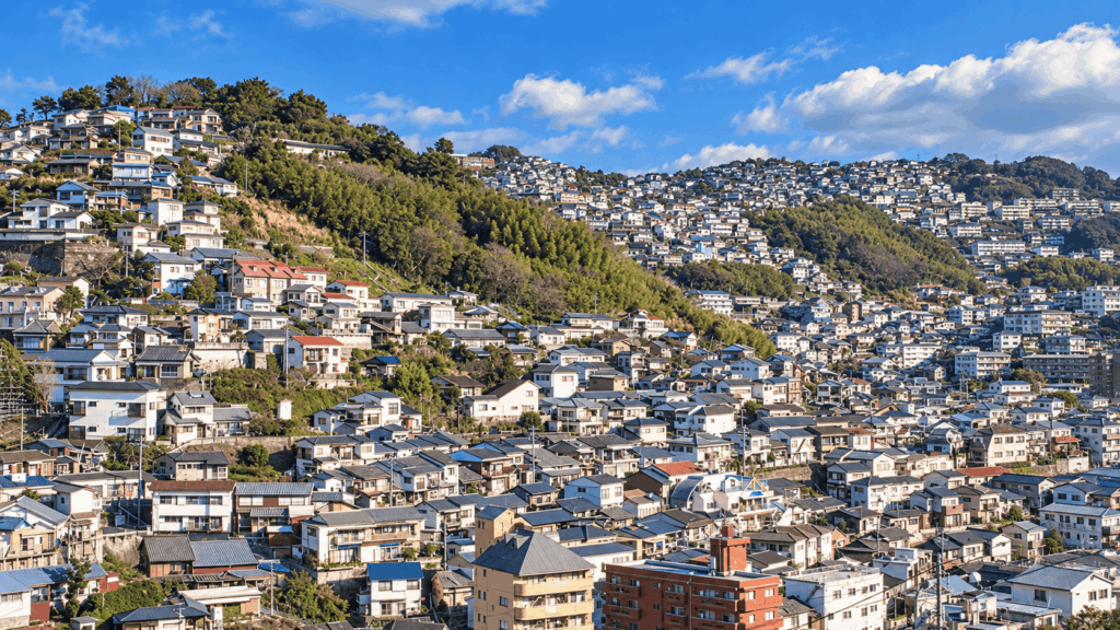 Panoramic view of densely packed hillside houses and residential neighborhoods on the steep slopes of Nagasaki, Japan